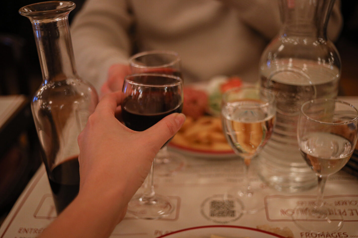 Verres de vin qui trinquent au Petit Bouillon Versailles